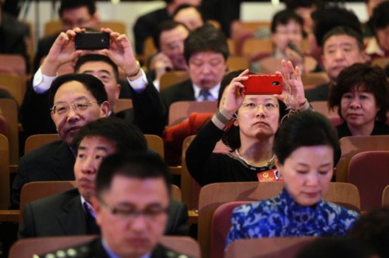Deputies take photos with their cellphones at the opening of the annual session of the Beijing Municipal Peoples Congress, the citys legislative body, on Tuesday. [CUI MENG / CHINA DAILY]