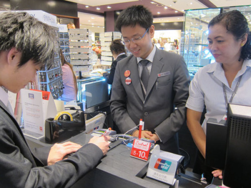 A Chinese tourist (left) pays a bill with the help of a translator in Central Chidlom, a flagship store in Bangkok, on Monday. Zhao Shengnan / China Daily 