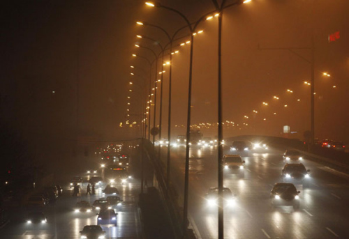 Cars move amid dense fog in Beijing on Jan 22, 2013. [Photo/Xinhua] 