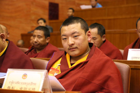 Radreng Sodnampuntsog, a 16-year-old Living Buddha and a political adviser of the Tibet autonomous region, attends the plenary session of the Tibet committee of China's political advisory body in Lhasa on Tuesday. He is the youngest adviser on the committee. DAQIONG / CHINA DAILY