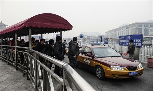 Passengers wait in line for cabs outside Beijing Railway Station Sunday afternoon. Photo: Li Hao/GT 