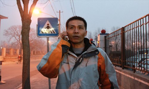 Zhu Ruifeng, the whistle-blower who exposed a series of sex scandals in Chongqing, talks to media via the phone after walking out of a police station in Xicheng district, Beijing on Monday. Photo: Chang Meng/GT 