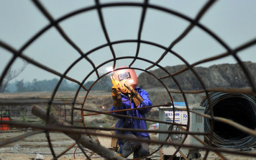 A worker welds at the construction site of the Wenchang Satellite Launch Center in Hainan province, which is expected to be completed in June and welcome its fi rst launch in 2014. [GUO CHENG / XINHUA]