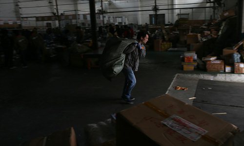 An express courier hauls packages Tuesday at a warehouse in Qingpu district. Photo: Cai Xianmin/GT 