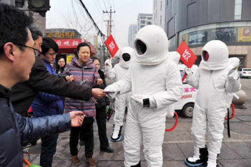 A man dressed as an astronaut hands out free masks on a street in Taiyuan city of North China's Shanxi province C one of China's coal mine hubs - on Jan 31, 2013. The recent smog across China has affected more than 800 million people, according to the Chinese Academy of Sciences. The Ministry of Environmental Protection said in a report issued on Wednesday that the recent smog has spread across the northern, central and eastern parts of the country. [Photo by Liu Jiang/Asianewsphoto]