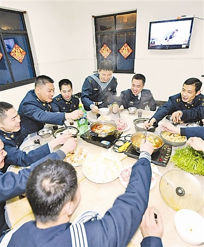 The officers and men of the transmitting station of a maritime garrison command under the East China Sea Fleet of the Navy of the Chinese Peoples Liberation Army (PLA) are enjoying hot pot food (a traditional Chinese food that people eat out of a pot of boiling soup on a small stove) and celebrating the Preliminary Eve (a holiday which falls on the 23rd or 24th of the twelfth month of the Chinese lunar year when people offer sacrifices to the kitchen god) on the night of February 3, 2013. The station has only 10-odd officers and men, and they cook by themselves. (Photo by Jiang Shan)