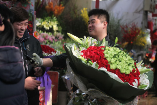 A florist finds romance can be a profitable business as he gets a bouquet ready for Valentine's Day in Beijing on Wednesday. Photo by Wang Jing / China Daily