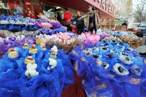 Customers select bouquets outside a flower shop in Yinchuan, capital of northwest China's Ningxia Hui Autonomous Region, Feb. 13, 2013. Florists in Yinchuan began their preparation of bouquets for the upcoming Valentine's Day. (Xinhua/Peng Zhaozhi) 