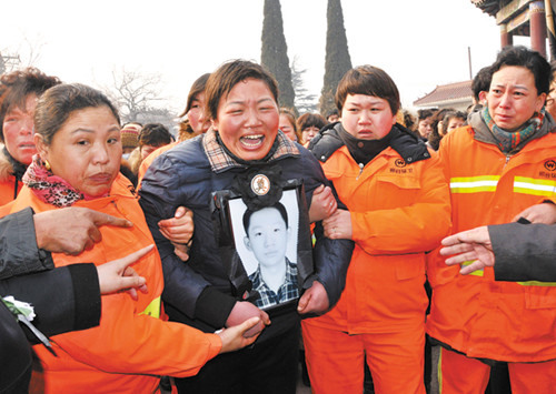 Relatives and friends offer support to the grief-stricken mother of Ren Wei at a memorial service in Xingtai, Hebei province, on Wednesday. Ren, 16, died on Saturday when rescuing a drowning man. [Huang Tao / For China Daily]