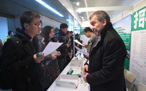 A job seeker speaks with a recruiter who represents a foreign-funded enterprise at a job fair organized by the Beijing Municipal Bureau of Human Resources and Social Security at the China International Exhibition Center in Beijing on Sunday. Zou Hong / Ch