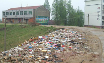 Waste is dumped in an open space alongside a road in a village in China.