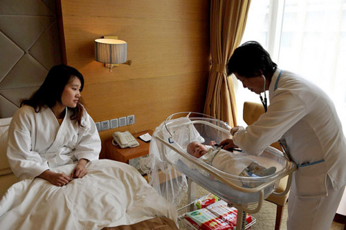A doctor checks a newborn at a postnatal care center in Shanghai. The center boasts fi ve-star services including pairing each mother with a team composed of a gynecologist, obstetrician, pediatrician, nutritionist and psychologist. [China Daily]