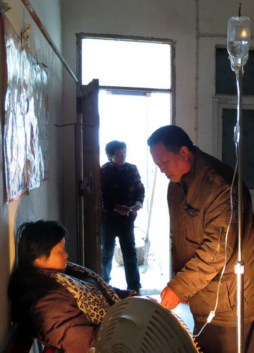 Zhang Zhenjiang, a doctor in Lixin county, Anhui province, takes care of an AIDS patient. [WANG XIAODONG / CHINA DAILY]