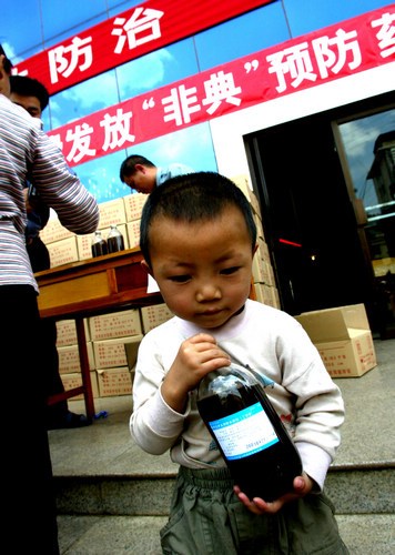 A child in Kunming, capital of Yunnan province, receiving free traditional Chinese medicine during the SARS outbreak. [BAO LIHUI / FOR CHINA DAILY] 