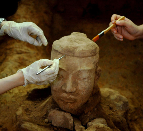 Scientists clean up unearthed terracotta worriors in Xi'an, Shaanxi province on Dec 20, 2012. [Photo/Xinhua]