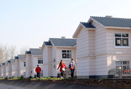 Villagers pass newly built houses at Yuantun village in Jiaozuo city, Henan province. The provinces urban population accounted for 42.2 percent of its total population at the end of 2012, a year-on-year rise of 1.8 percentage points. [Photo/Xinhua] 