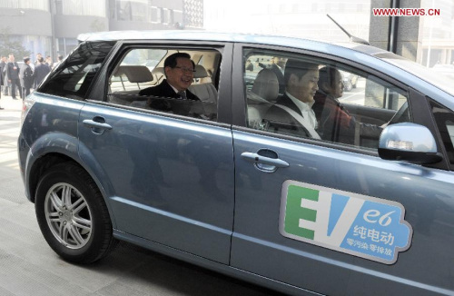 Wan Gang (L), the minister of science and technology, takes an electric vehicle (EV) to leave after a panel discussion in Beijing, capital of China, March 7, 2013. The minister said to reporters that zero-emission electric vehicles had been sold in Chines