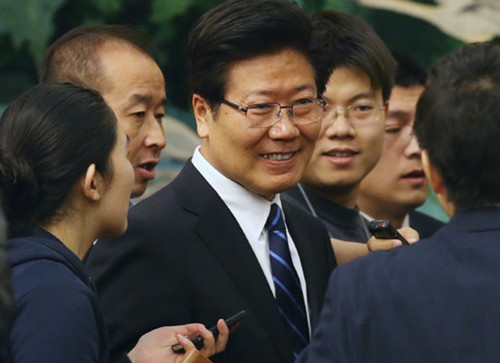 Zhang Chunxian, Party chief of the Xinjiang Uygur autonomous region, is crowded by the press after a group discussion by the Xinjiang delegation during the first session of the 12th NPC in Beijing on Thursday. [Xu Jingxing / China Daily]