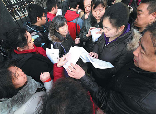 An employee distributes material needed for secondhand home transactions at a housing center in Beijing. [Photo/China Daily]