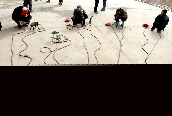 Residents in Huayuan village practice electric welding during a training session, March 11, 2013. [Photo/Asianewsphoto]