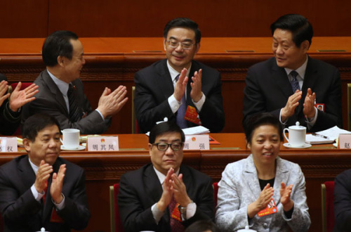 Deputies to the National People's Congress congratulate Zhou Qiang (back, center) after he was elected president of the Supreme Peoples Court on Friday. [Xu Jingxing / China Daily]