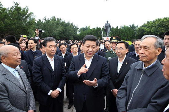 In this file photo taken on Dec. 8, 2012, Xi Jinping (3rd L, front) talks with people around him after he presented flowers to the statue of Deng Xiaoping at Shenzhen Lianhuashan Park in Shenzhen, south China's Guangdong Province. (Xinhua/Lan Hongguang)
