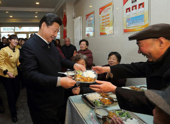 In this file photo taken on Feb. 4, 2013, Xi Jinping (L, front) serves food to an old man as he visits a cafeteria in a senior citizens' center in Lanzhou, capital of northwest China's Gansu Province. (Xinhua/Lan Hongguang)