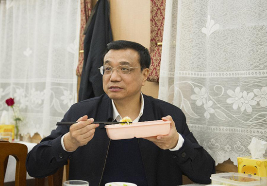 In this file photo taken on Dec. 28, 2012, Li Keqiang eats packed lunch on the train from Dangyang to Enshi Tujia and Miao Autonomous Prefecture in central China's Hubei Province. (Xinhua) 