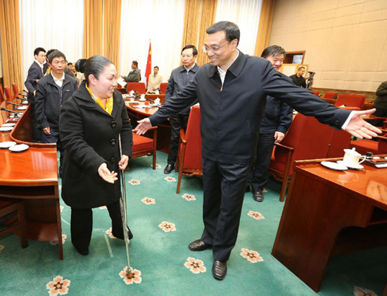 In this file photo taken on Jan. 5, 2013, Li Keqiang (R, front) asks Zhou Yuehua (L), a rural doctor from a village in Chongqing, to go before him after his meeting with Zhou and 17 other model rural doctors in Beijing, capital of China.(Xinhua/Yao Dawei) 
