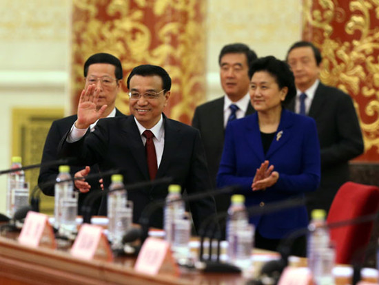 Premier Li Keqiang waves to journalists as he and four vice-premiers arrive for the news conference following the conclusion of the annual national legislative session on Sunday. Xu jingxing / China Daily