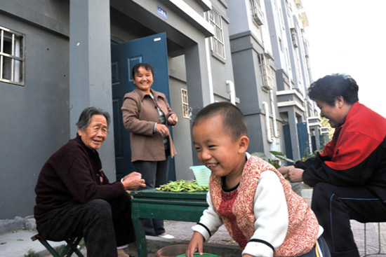 Residents of a former shantytown that was redeveloped enjoy a light moment in Zaozhuang, Shandong province, in October. [Photo/Xinhua]