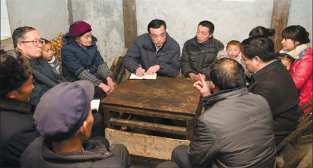 On Jan 5, Li asks Zhou Yuehua (left), a rural doctor from a village in Chongqing, to go before him after his meeting with Zhou and 17 other model rural doctors in Beijing. [Photo/Xinhua]
