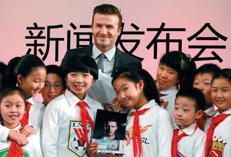 David Beckham poses with students of a Beijing primary school on Wednesday. The former England captain arrived in China on Tuesday as a special ambassador for Chinese soccer. Cui Meng / China Daily