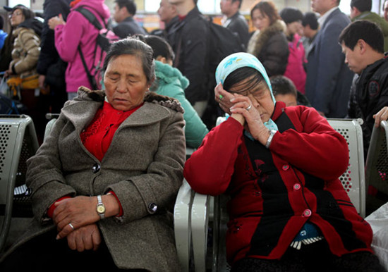 Passengers nap in a Beijing train station waiting room on Thursday, which was World Sleep Day.