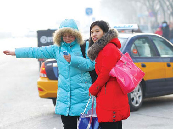 Commuters flag down a cab during the morning rush hour at Beijing's Dongzhimen area on Jan 16. Use of new mobile apps could help cab drivers increase their income while providing convenience to passengers. [Zou Hong / China Daily]