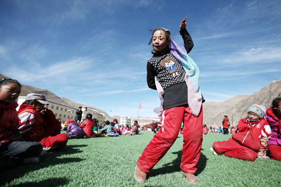 A Tibetan girl dances on a playground at the China-Congo Friendship Primary School, which was built with the help of an investment of 16 million yuan ($2.57 million) from the Republic of Congo. Photos by Wang Jing / China Daily