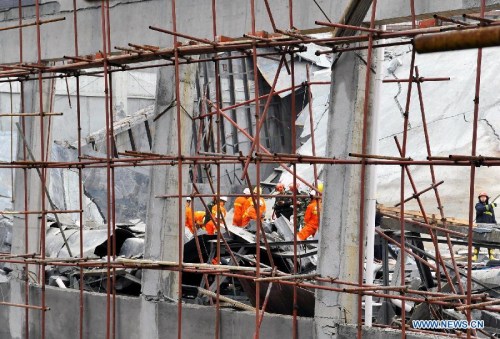 Firefighters conduct search and rescue work at the scene of a building collapse accident in Zixing City, central China's Hunan Province, March 27, 2013. Part of a hotel under construction collapsed on Wednesday morning, which buried six people, five of wh