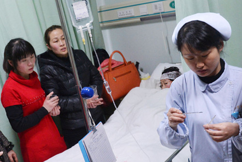 A student who was injured in a violent assault by a man who slashed and injured 11 passers-by after killing two of his relatives in Shanghai, receives treatment at Fengxian Central Hospital on Wednesday. XU CHENG / FOR CHINA DAILY