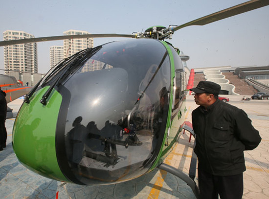 A visitor checks a helicopter on sale at a private aircraft store in Beijing on Saturday. JIANG GUIJIA / FOR CHINA DAILY