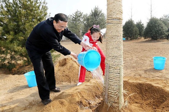 Li Keqiang (L) waters a tree together with a pupil during a tree-planting event in Fengtai District in Beijing, capital of China, April 2, 2013. Chinese top leaders Xi Jinping, Li Keqiang, Zhang Dejiang, Yu Zhengsheng, Liu Yunshan, Wang Qishan and Zhang G