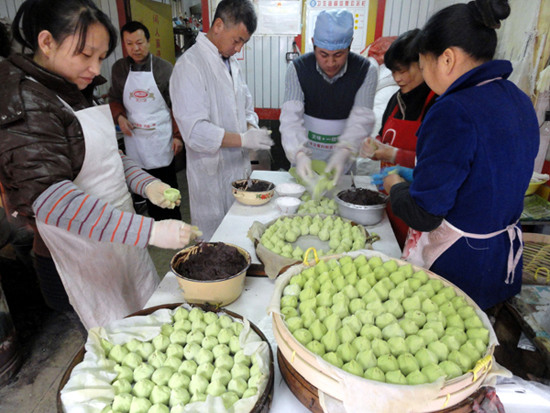 Workers make qingtuan, or green rice balls, at a pastry shop in Suzhou, Jiangsu province. Qingtuan are a traditional Qingming snack for people living south of the Yangtze River. Wang Jiankang / for China Daily