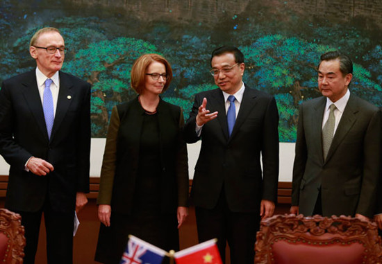 Premier Li Keqiang chats with his Australian counterpart Julia Gillard at a ceremony for the signing of agreements in Beijing on Tuesday. Feng Yongbin / China Daily