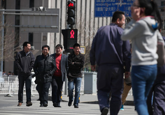 Pedestrians jaywalk on a street near the China World Trade Center in Beijing on Tuesday. Wang Jing / China Daily