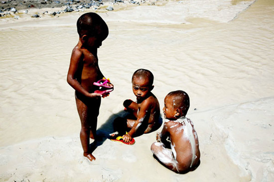 Children on the bank of a polluted river in Dongchuan district in Kunming, Yunnan province, in March. GUO TIELIU / FOR China Daily