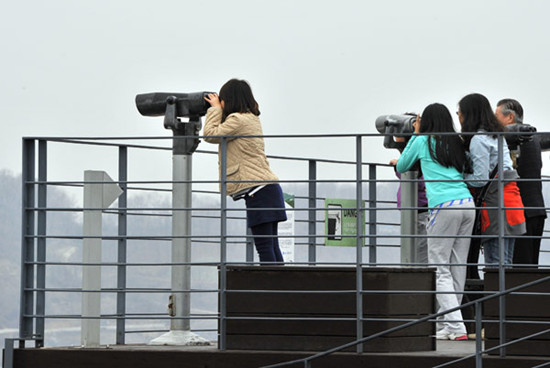 Visitors look toward the DPRK at a park near the demilitarized zone between the ROK and the DPRK, in the border city of Paju. Jung Yeon-Je / Agence France-Presse
