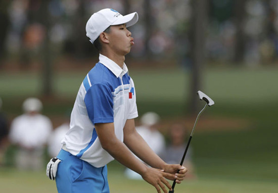 Fourteen-year-old Amateur Guan Tianlang of China reacts to missing a birdie putt on the second green during first round play in the 2013 Masters golf tournament at the Augusta National Golf Club in Augusta, Georgia, April 11, 2013.  [Photo/Agencies]