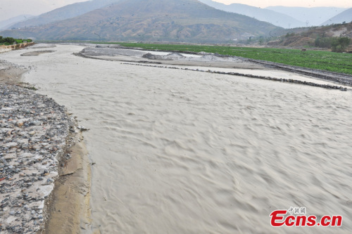 Photo taken on April 1, 2013 shows a polluted stream which has turned white in Dongchuan district of Kunming city, Yunnan province. On the benchland was white sludge, giving out odor of chemical reagent. A vegetable field nearby was covered by ashy soils. Locals began calling the river milk river after pollutants from a nearby underdrainage turned the water white.(CNS/Ren Dong)