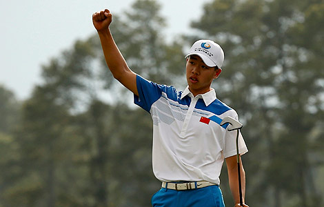 Fourteen-year-old amateur Guan Tianlang of China celebrates sinking a birdie putt on the 18th green during first round play in the 2013 Masters golf tournament at the Augusta National Golf Club in Augusta, Georgia, April 11, 2013. [Photo/Agencies]