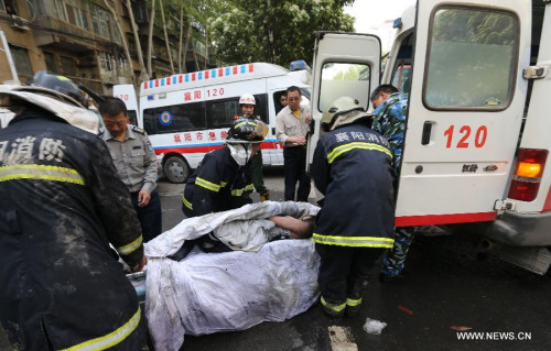 Firefighters remove an injured person to the ambulance after a fire occurred at a hotel in Fancheng District of Xiangyang City, central China's Hubei Province, April 14, 2013. (Xinhua Photo)
