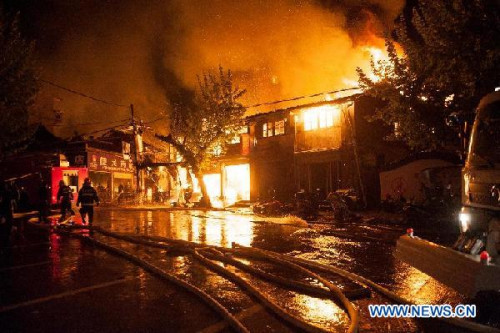 Firemen work at the scene of a fire in Jingning She Autonomous County, east China's Zhejiang Province, April 15, 2013. The fire broke out at around 8:50 p.m. local time in the old downtown area of Jingning. The number of casualties is not yet known. Firefighters are rushing to put out the fire. (Xinhua/Li Suren)